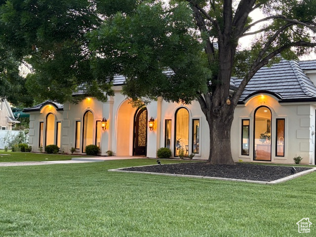 View of front of property featuring a front yard and stucco siding