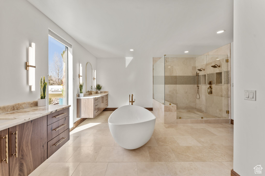 Full bath with a stall shower, a freestanding tub, two vanities, and recessed lighting