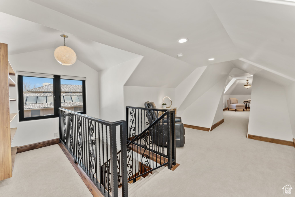 Corridor featuring vaulted ceiling, carpet floors, an upstairs landing, and baseboards