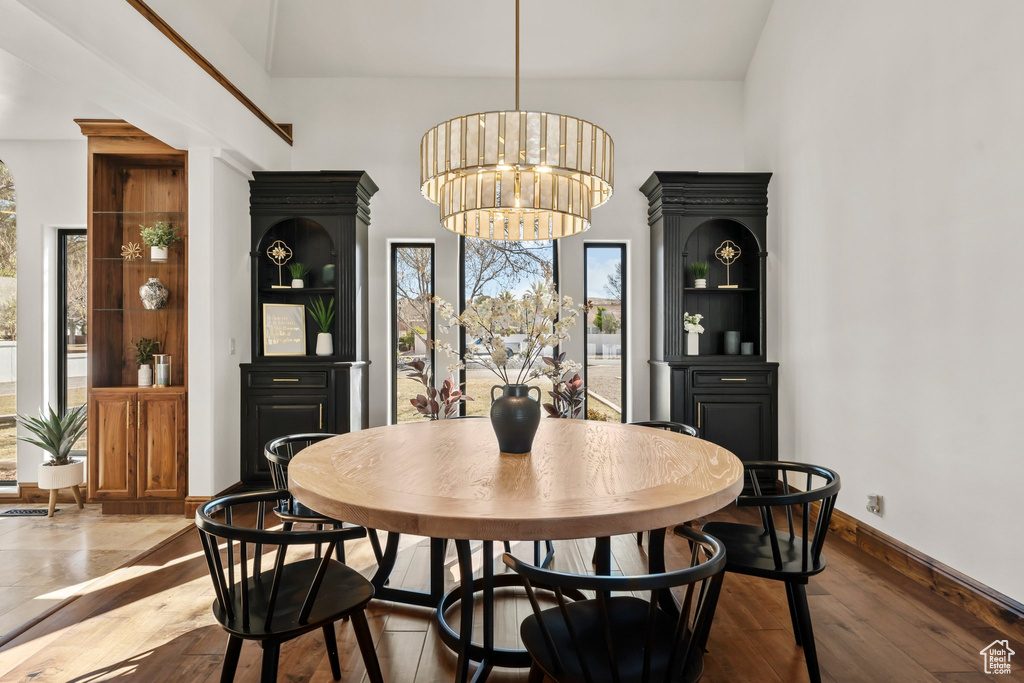 Dining area featuring a chandelier, wood finished floors, and baseboards