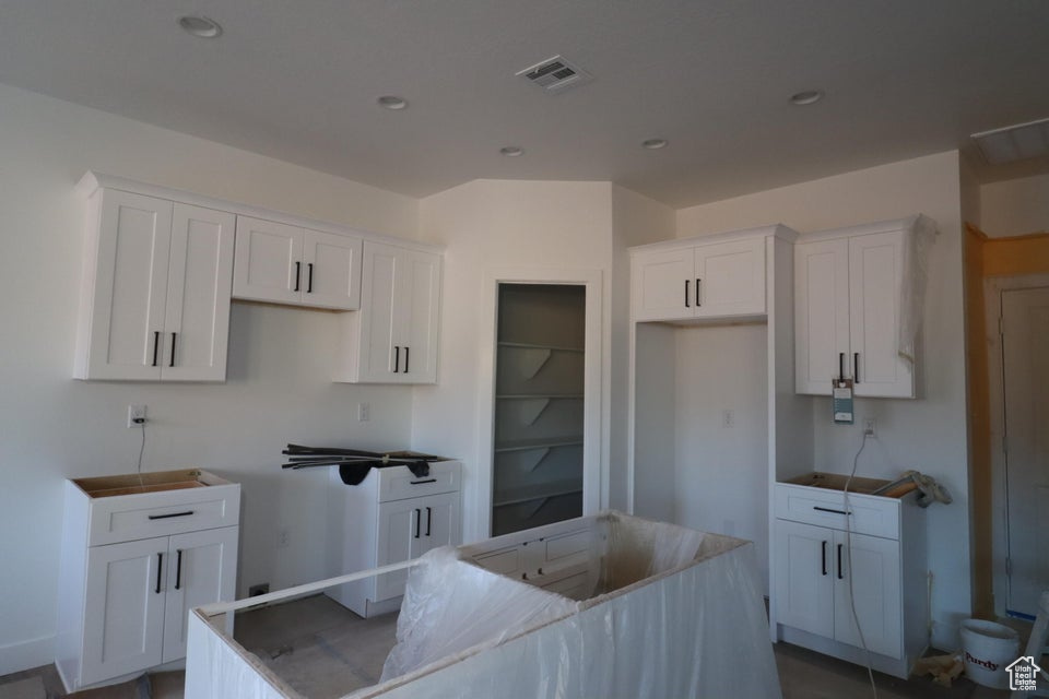 Kitchen with recessed lighting, a center island, and white cabinets
