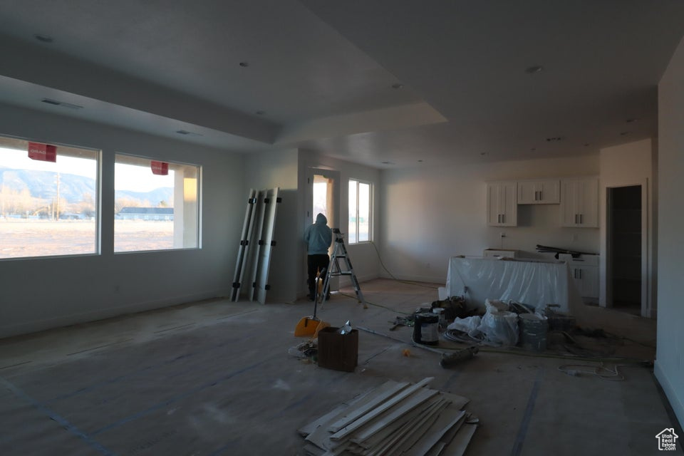 Living area featuring baseboards, a raised ceiling, and visible vents