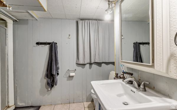 Bathroom featuring toilet, tile patterned floors, and a sink