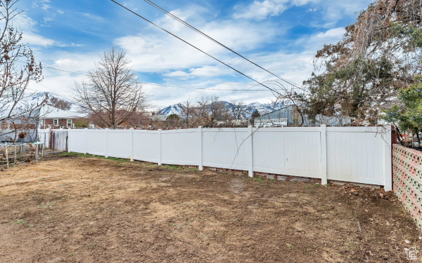 View of yard with a trampoline and a fenced backyard