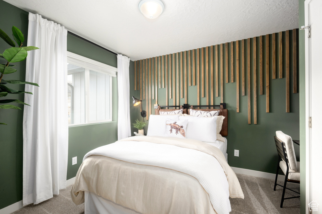 Bedroom featuring carpet and baseboards