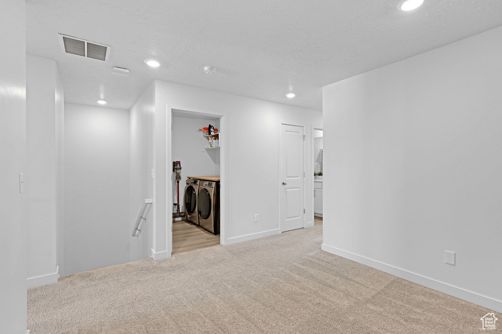 Spare room with light colored carpet, visible vents, recessed lighting, washing machine and clothes dryer, and baseboards