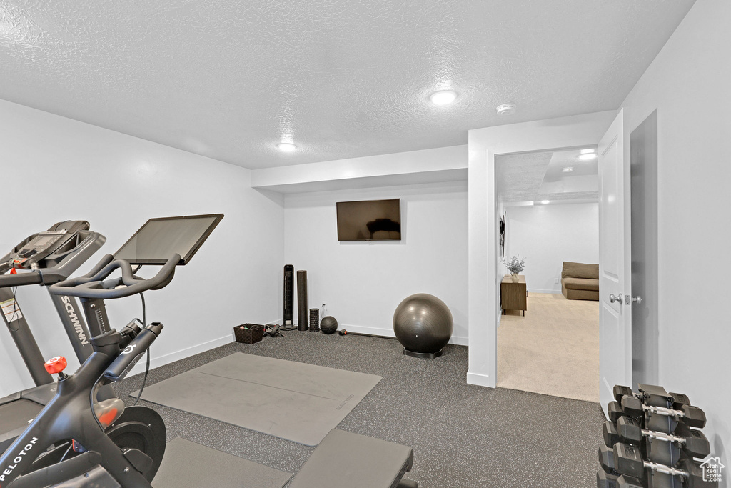Exercise room featuring baseboards and a textured ceiling