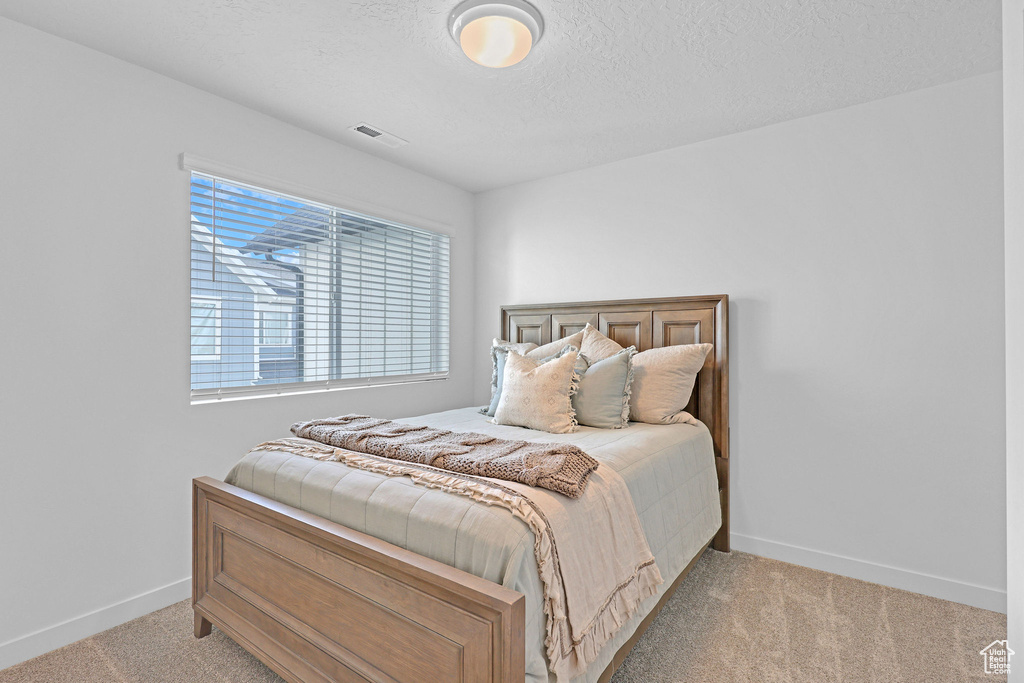 Bedroom with baseboards, carpet flooring, and visible vents