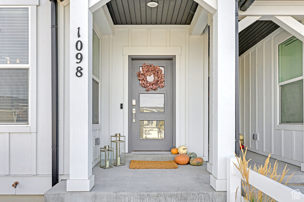 View of exterior entry featuring covered porch and board and batten siding