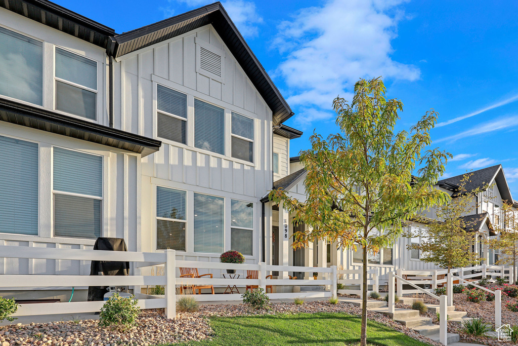 Back of house with board and batten siding and a fenced front yard