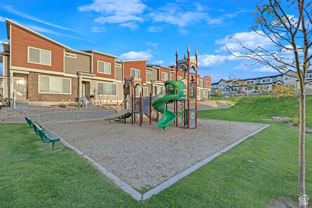 Communal playground featuring a yard and a residential view