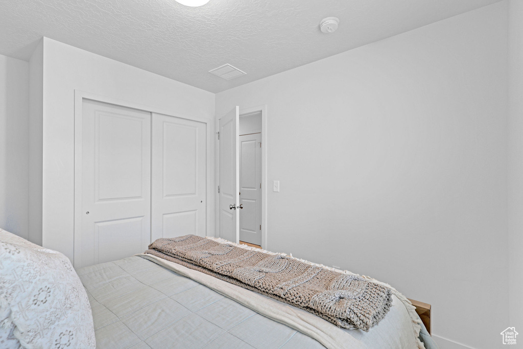 Bedroom with a closet and a textured ceiling