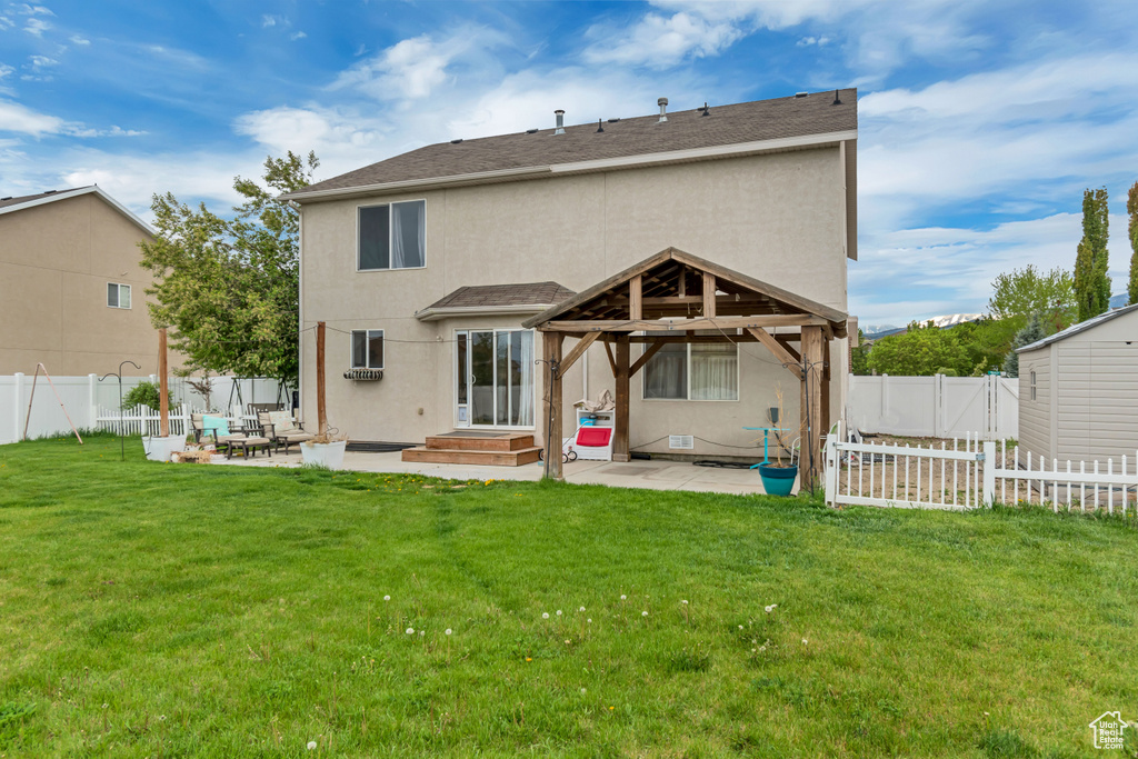 Back of house with a lawn, a gazebo, a patio, and stucco siding