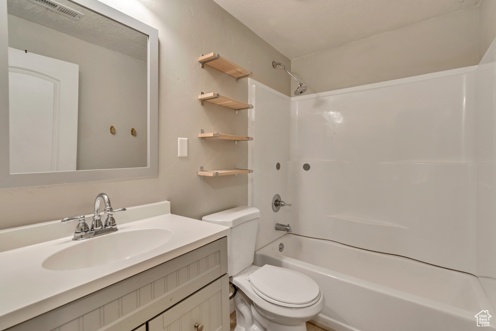 Bathroom with toilet, visible vents, vanity, and washtub / shower combination