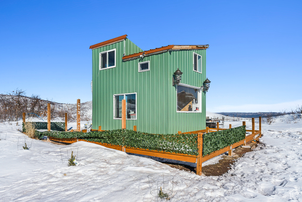 Snow covered property featuring board and batten siding