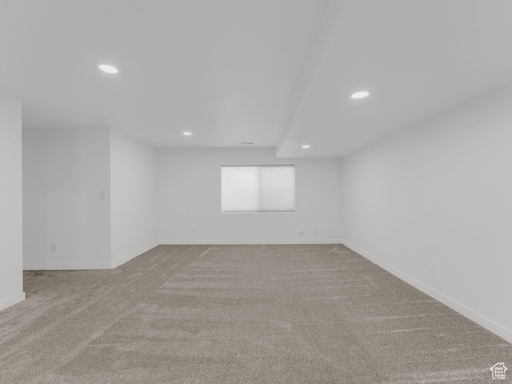 Empty room featuring carpet flooring, baseboards, and recessed lighting