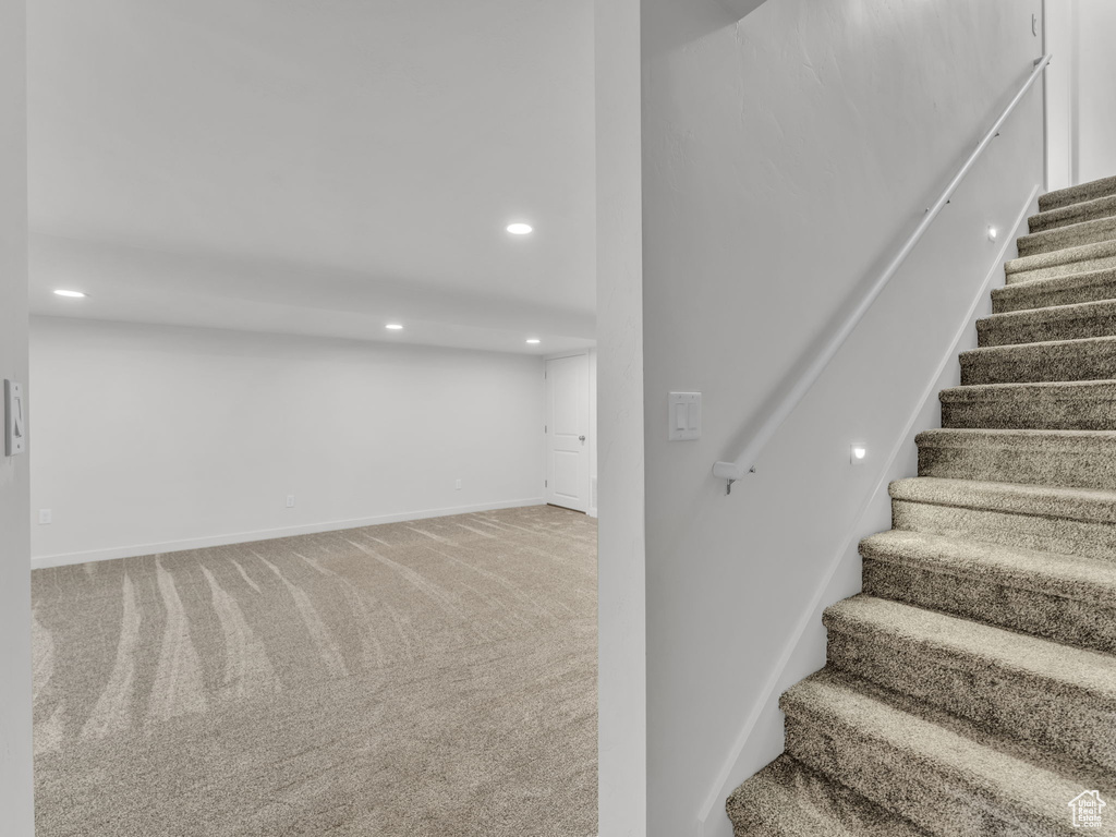 Staircase featuring carpet floors, baseboards, and recessed lighting