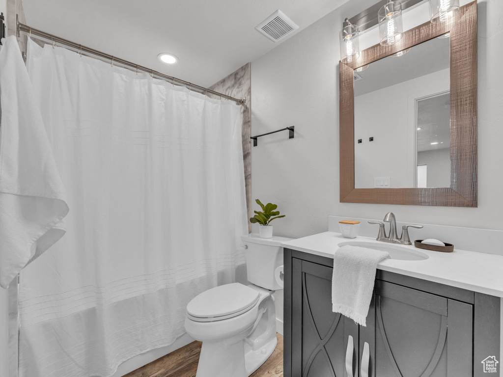 Bathroom featuring recessed lighting, toilet, visible vents, vanity, and wood finished floors