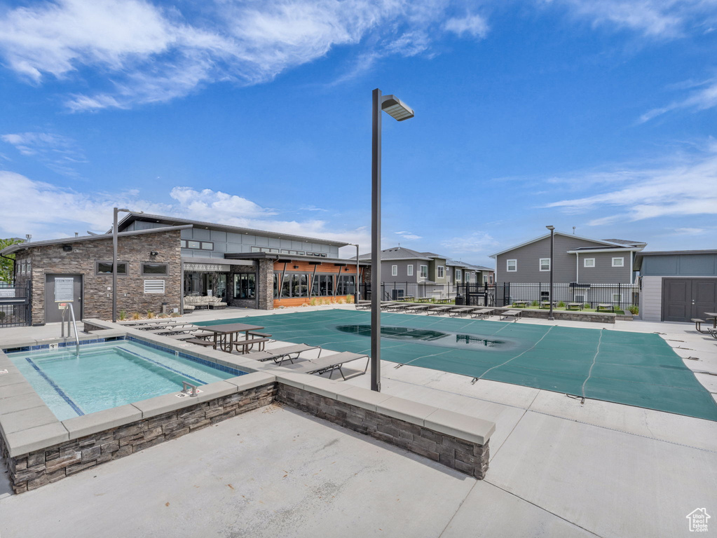 Community pool with a patio, a community hot tub, and fence