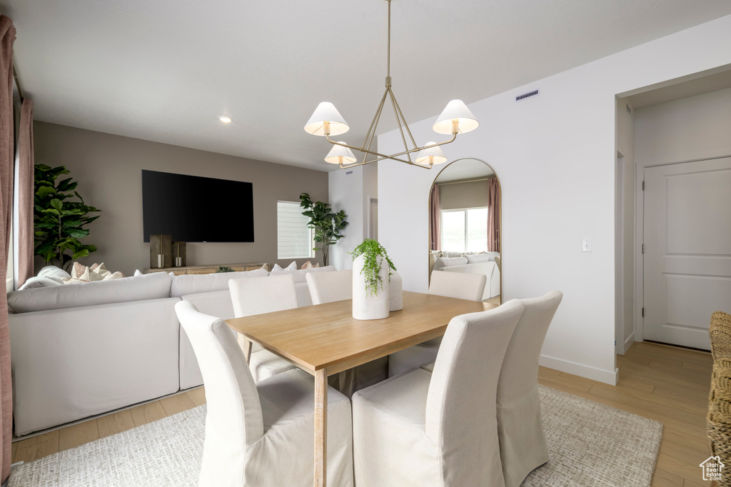 Dining area featuring recessed lighting, light wood finished floors, an inviting chandelier, arched walkways, and baseboards