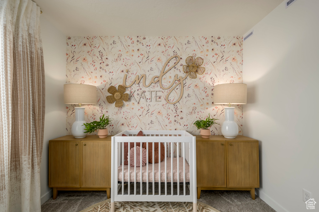 Carpeted bedroom featuring baseboards and a crib