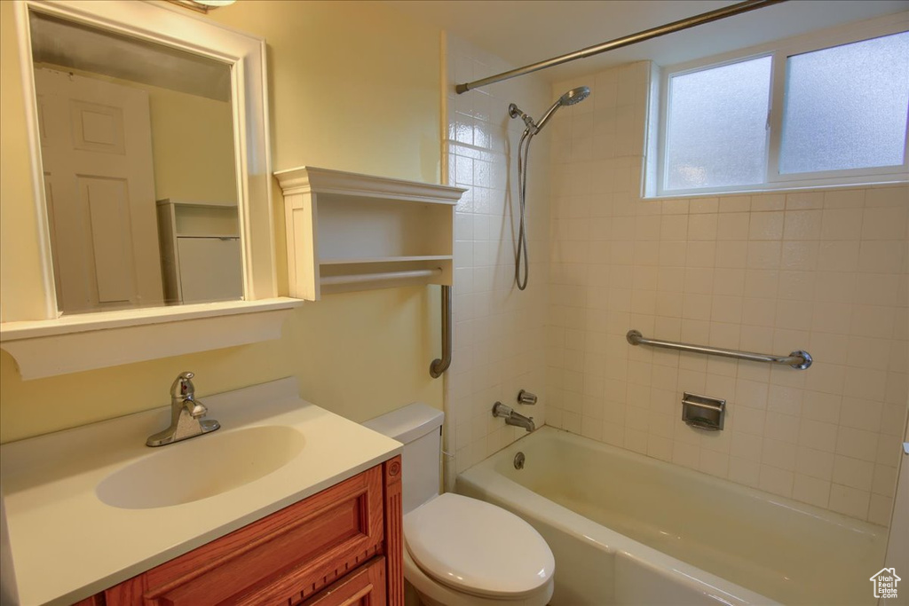 Bathroom with bathtub / shower combination, toilet, and vanity