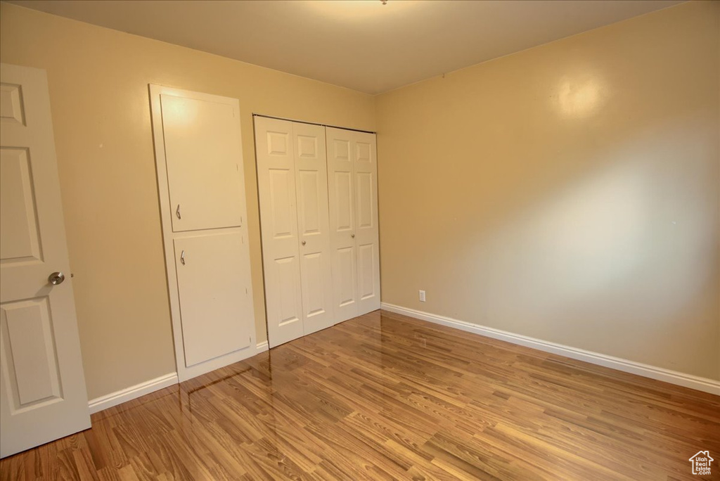 Unfurnished bedroom with baseboards, light wood finished floors, and a closet