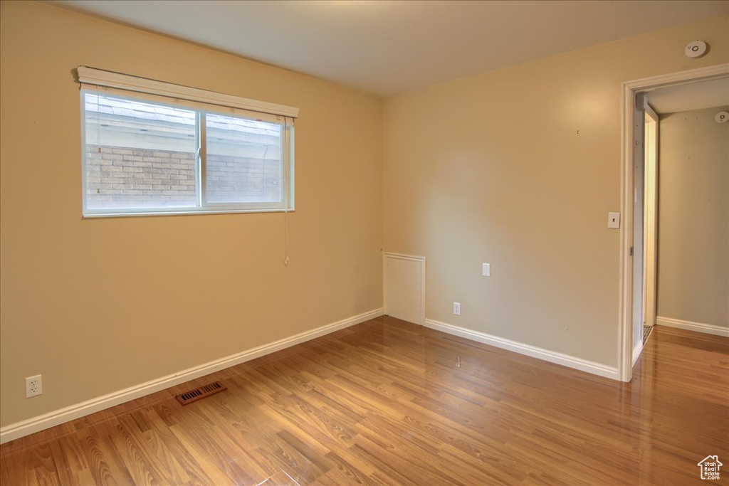 Unfurnished room featuring baseboards, light wood finished floors, and visible vents