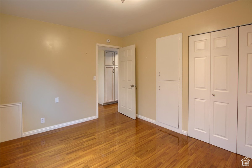 Unfurnished bedroom with baseboards, light wood-type flooring, and a closet