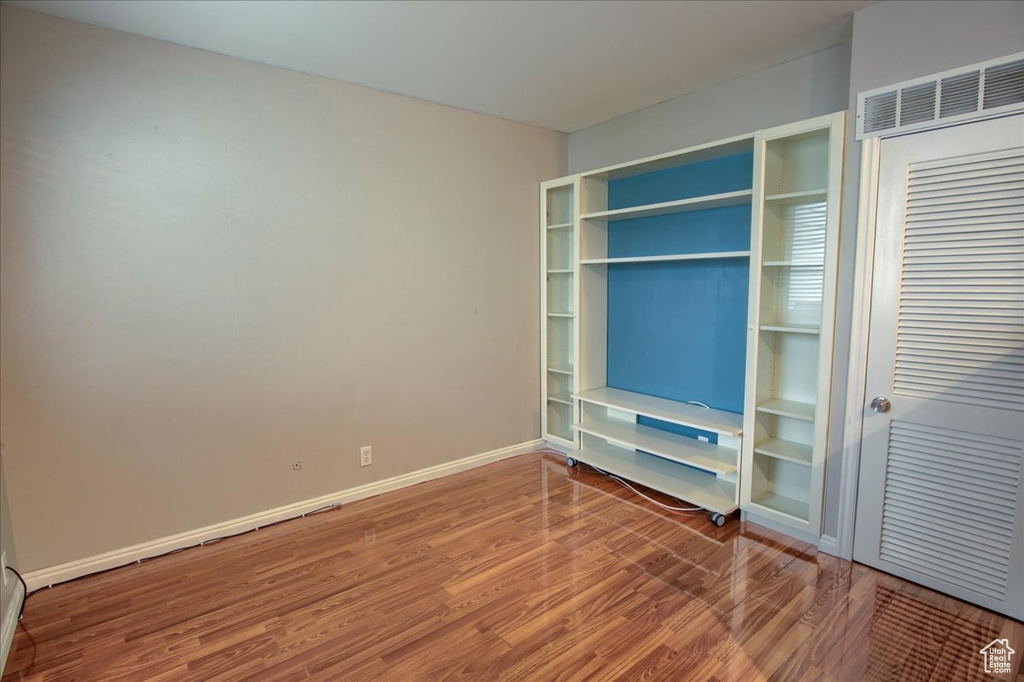 Unfurnished bedroom with wood finished floors and baseboards