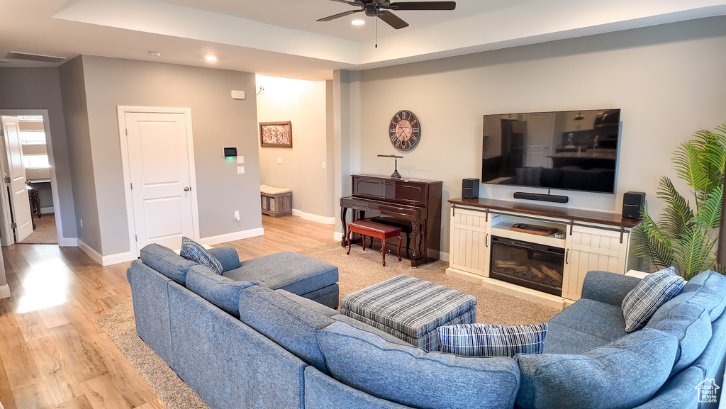 Living room with a ceiling fan, light wood-style floors, recessed lighting, and baseboards