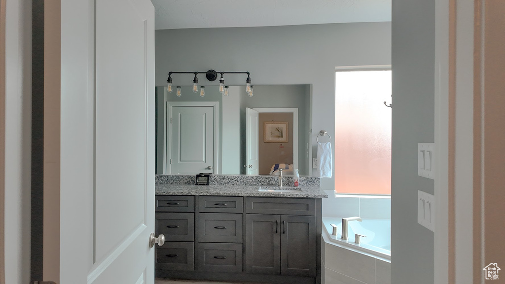 Full bathroom with vanity and a garden tub