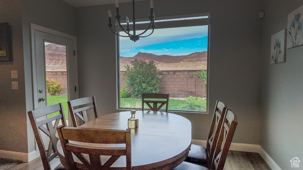 Dining space with a notable chandelier, baseboards, and wood finished floors