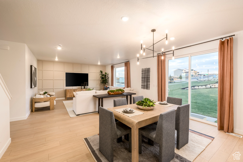 Dining space with light wood-style flooring, baseboards, and plenty of natural light