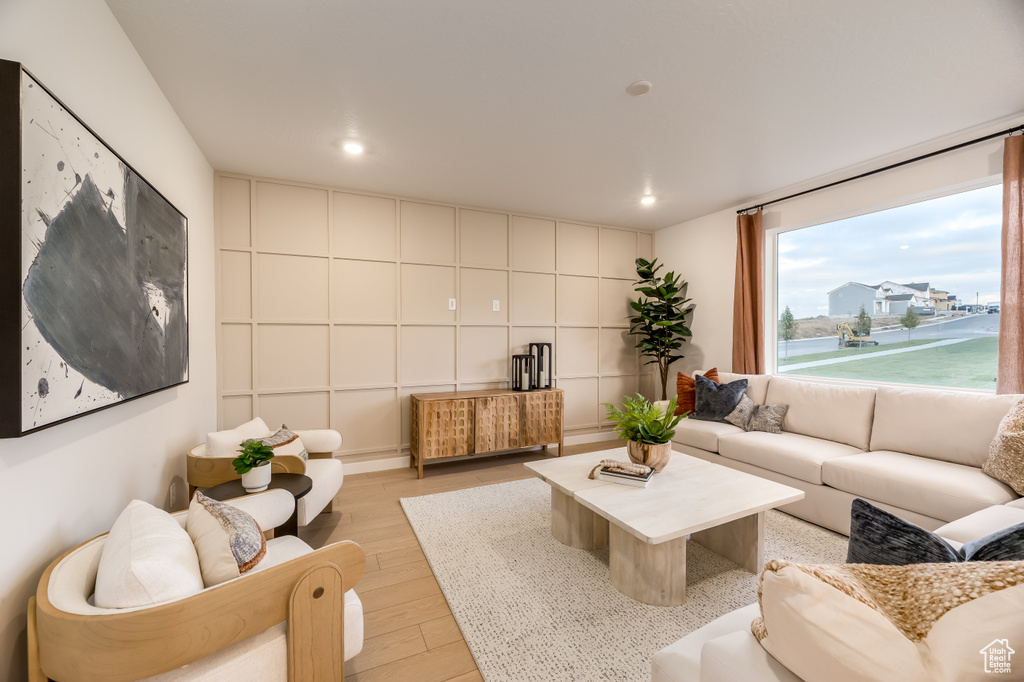 Living area with light wood finished floors and recessed lighting