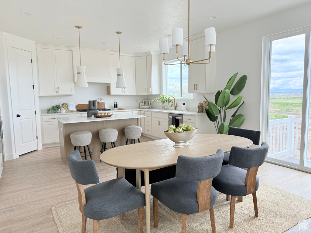 Dining room with light wood finished floors and recessed lighting