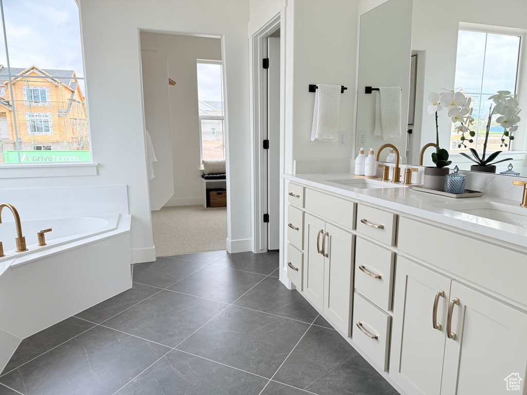 Full bath with a bath, double vanity, and tile patterned flooring