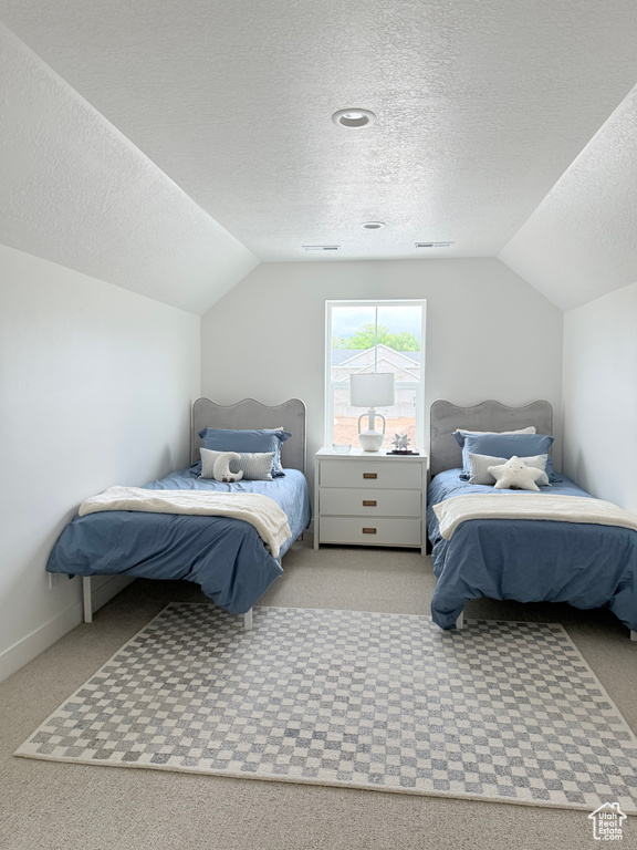Bedroom featuring vaulted ceiling, carpet floors, a textured ceiling, and baseboards
