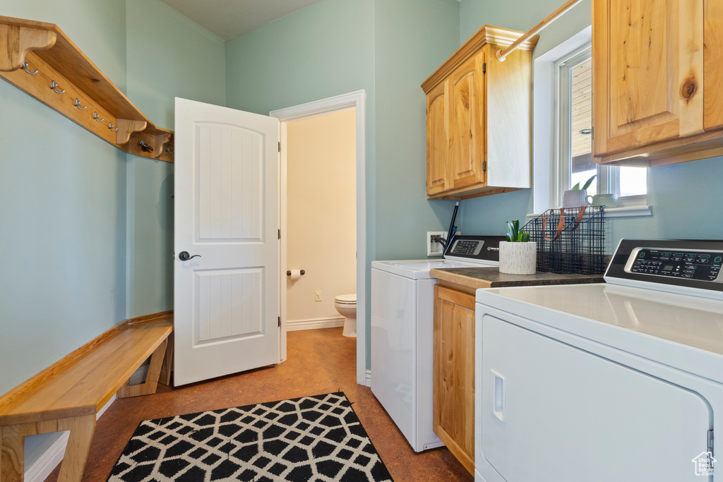 Laundry area featuring separate washer and dryer and cabinet space