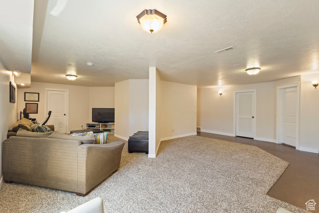 Living area with baseboards, visible vents, and a textured ceiling