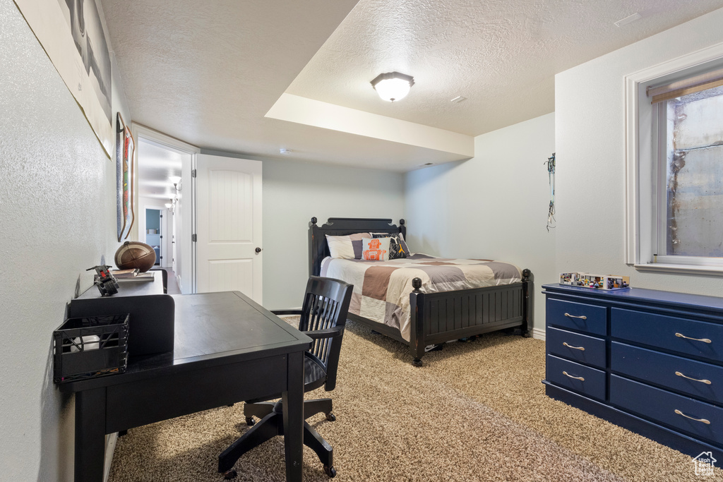 Bedroom featuring light colored carpet, a textured ceiling, and baseboards