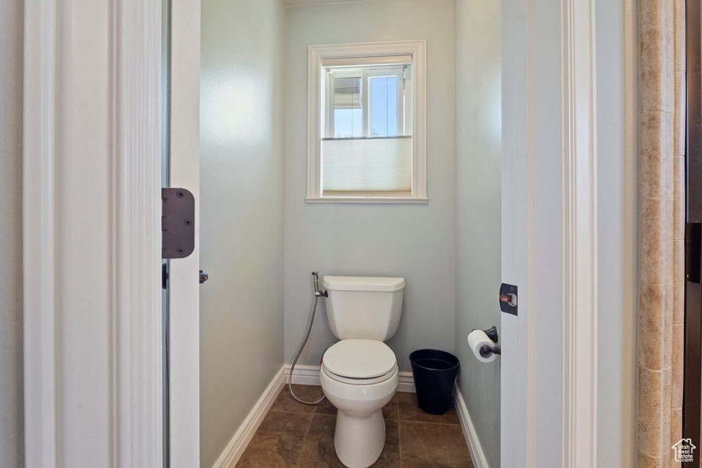 Bathroom with tile patterned flooring, toilet, and baseboards