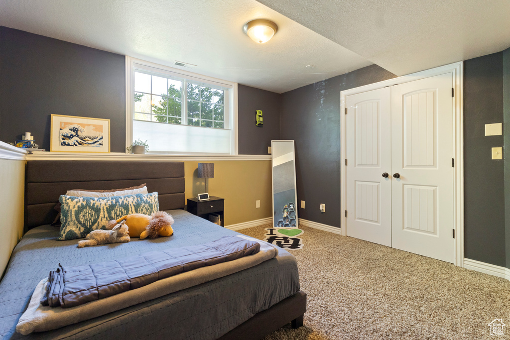 Bedroom with carpet flooring, baseboards, a closet, and visible vents