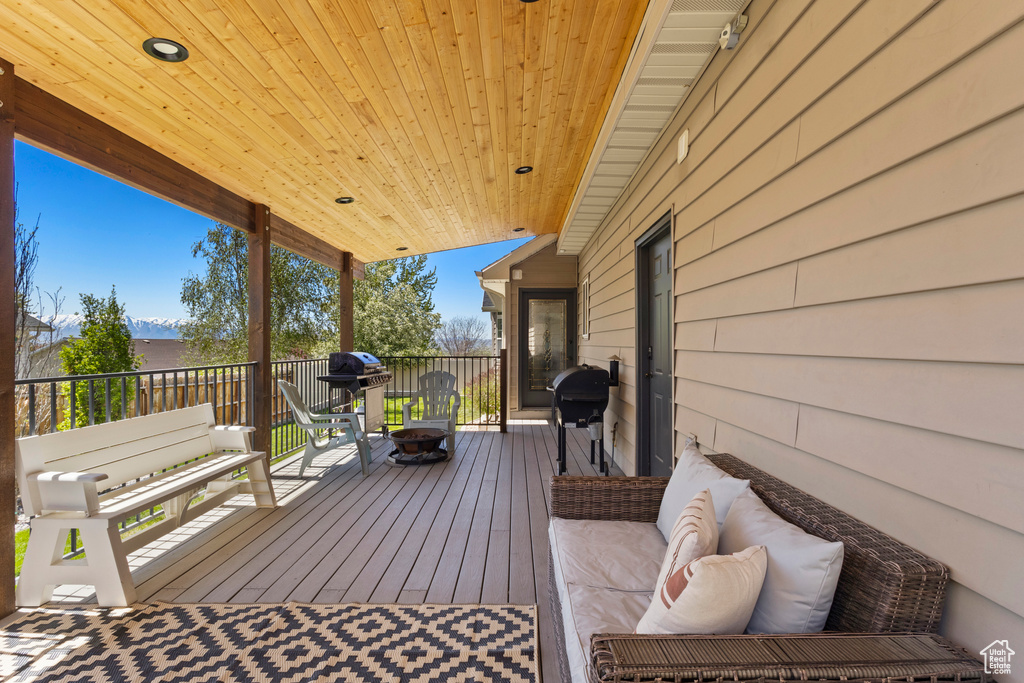 Wooden deck with an outdoor fire pit and area for grilling