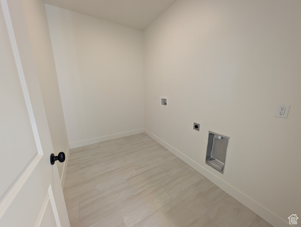 Clothes washing area featuring laundry area, hookup for an electric dryer, baseboards, and hookup for a washing machine