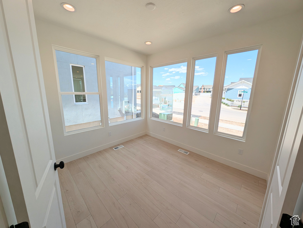Unfurnished sunroom with baseboards, recessed lighting, visible vents, and wood finished floors