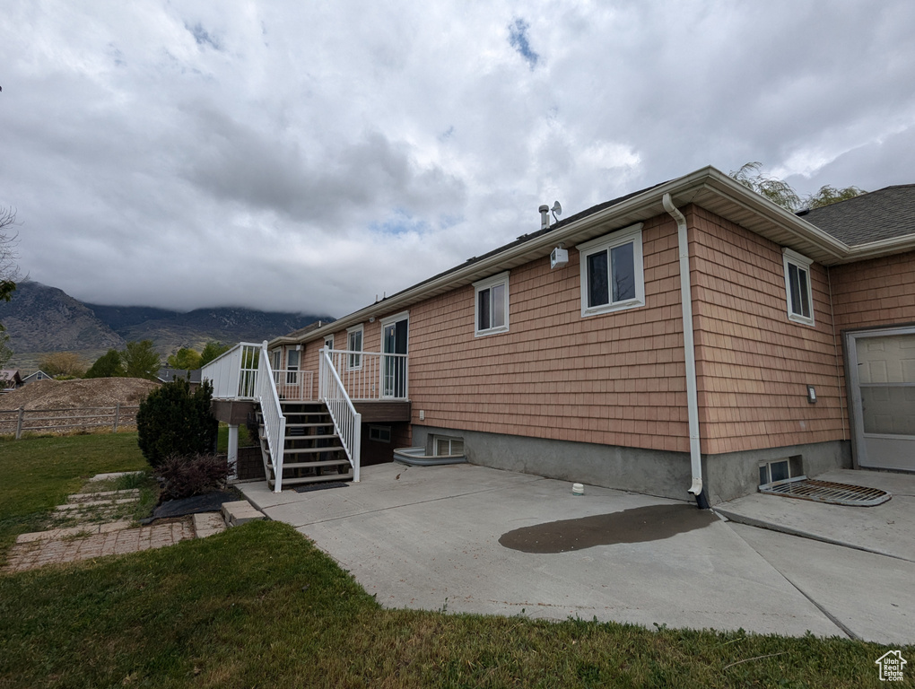 View of property exterior with stairway, a patio, and a deck with mountain view