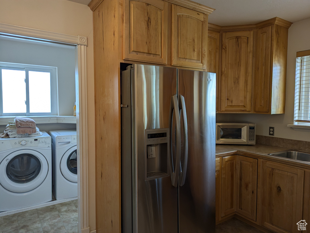 Kitchen featuring washing machine and dryer, stainless steel appliances, and a sink