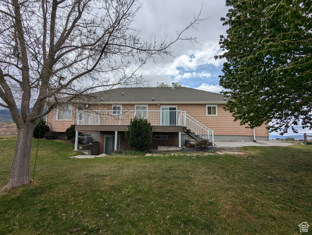 Back of property featuring a yard, a deck, and stairway