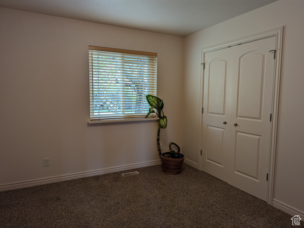 Unfurnished bedroom featuring carpet floors, baseboards, visible vents, and a closet